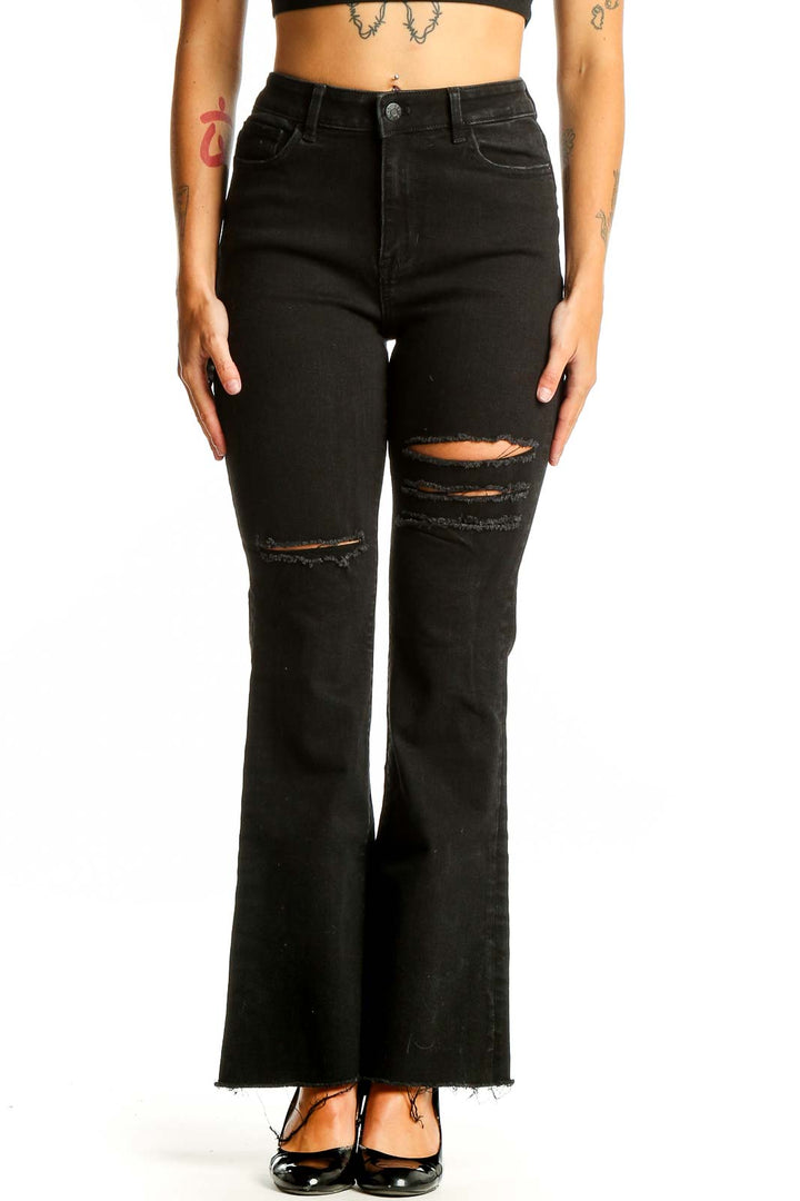 Front view of Guess black distressed flare jeans on model