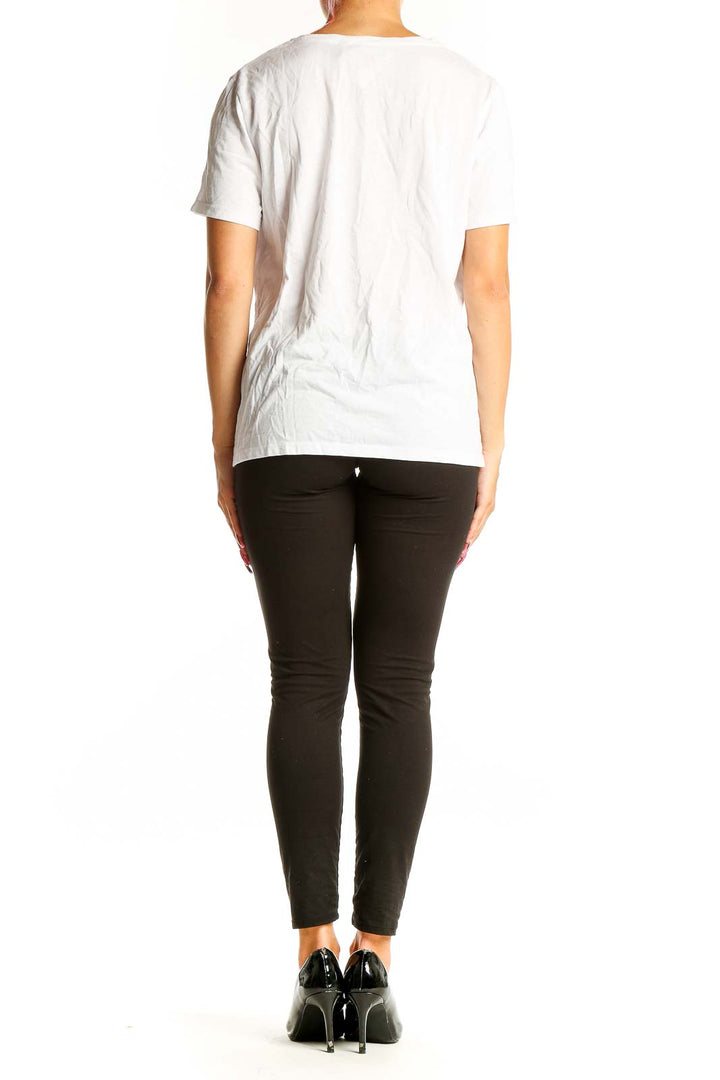 Side view of white Theory V-neck short sleeve top on model with black pants