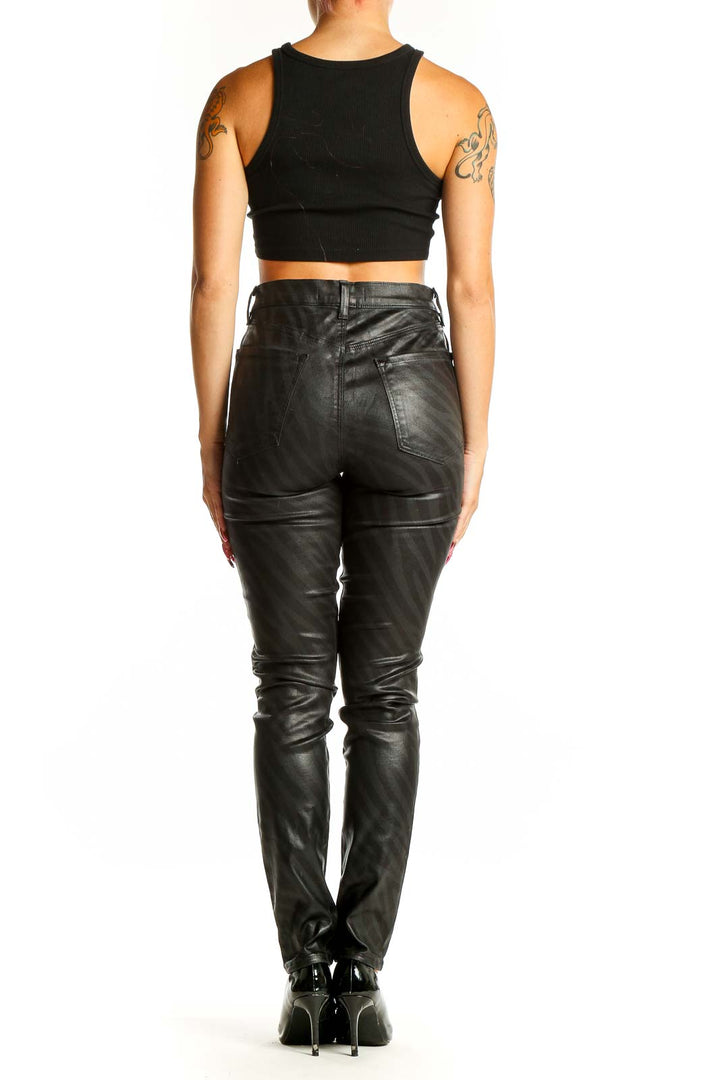 Side view of J Brand black faux leather skinny pants on model