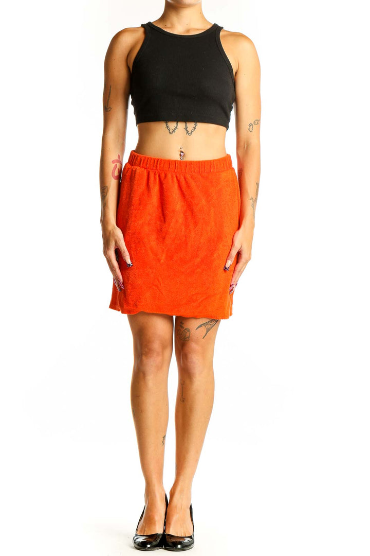 Front view of orange organic cotton mini skirt with side pockets
