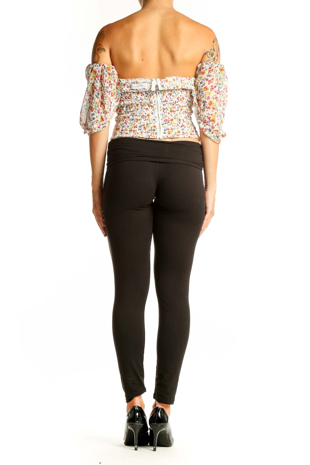Back view of Flynn Skye floral off-shoulder crop top paired with black pants