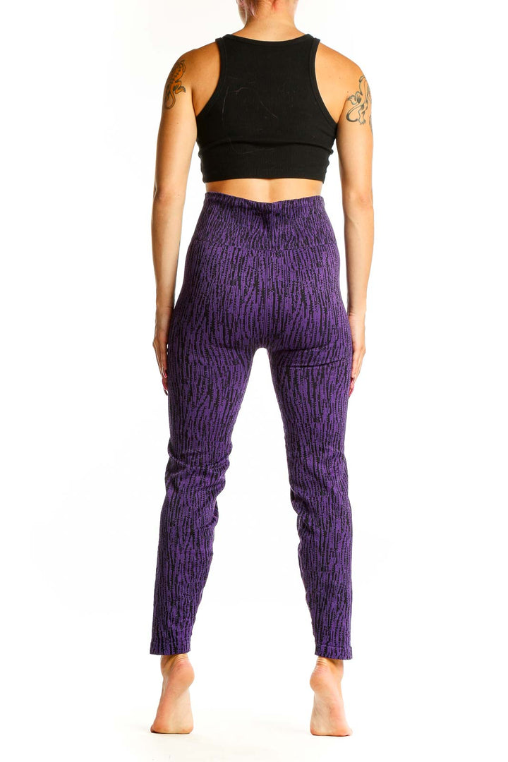 Side view of woman wearing purple textured Athleta leggings with black crop top