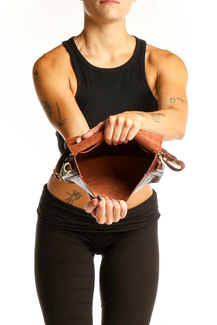 Side view of brown leather crossbody bag worn by model