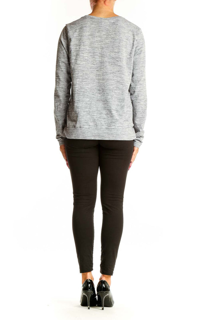 Side view of woman wearing Athleta gray heathered long sleeve top with black pants