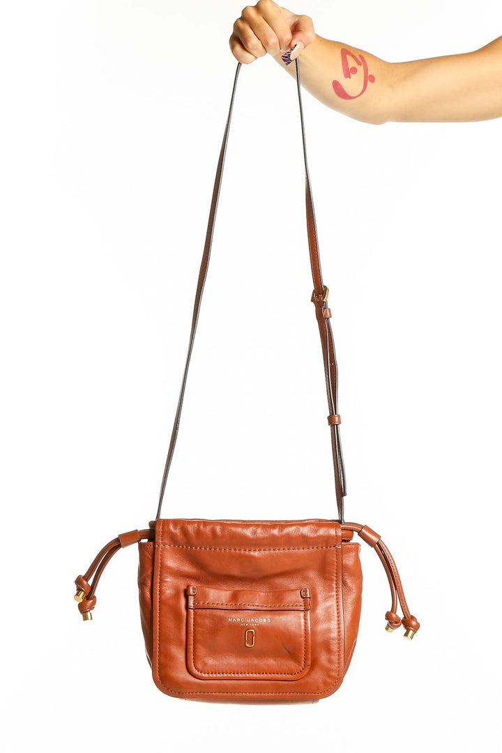 Front view of MARC JACOBS brown leather crossbody bag with drawstring closure