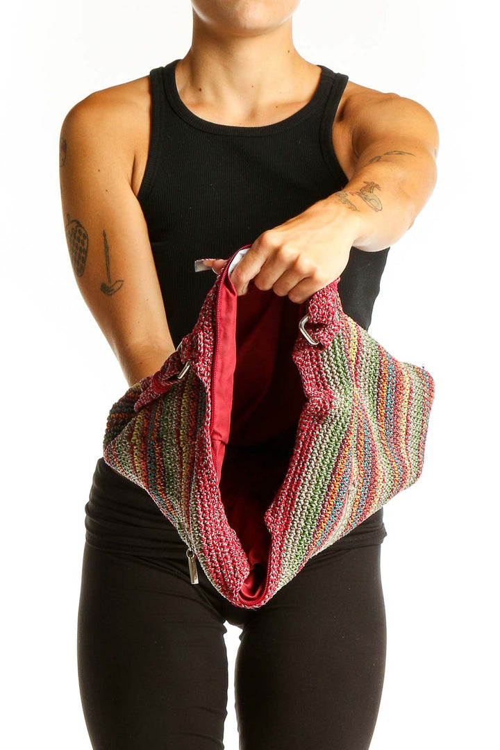 Side view of The Sak multicolor striped crochet shoulder bag worn by model