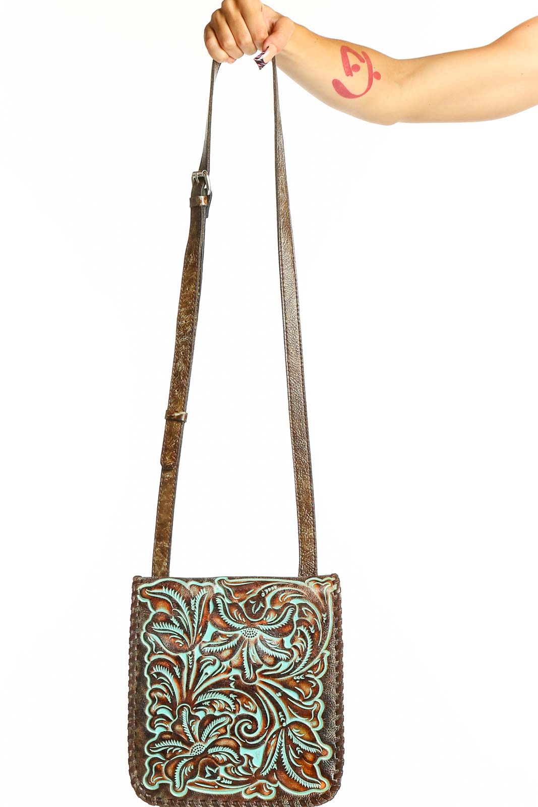 Front view of Patricia Nash brown tooled leather crossbody bag with turquoise floral design