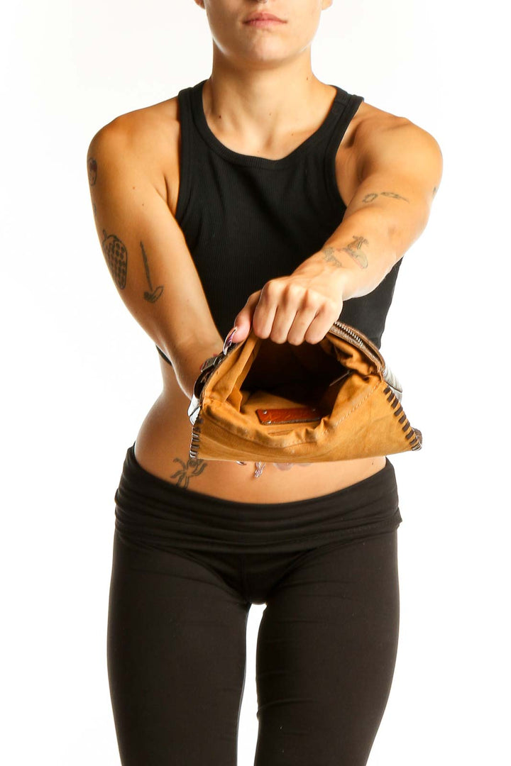 Side view of Patricia Nash brown tooled leather crossbody bag worn by model