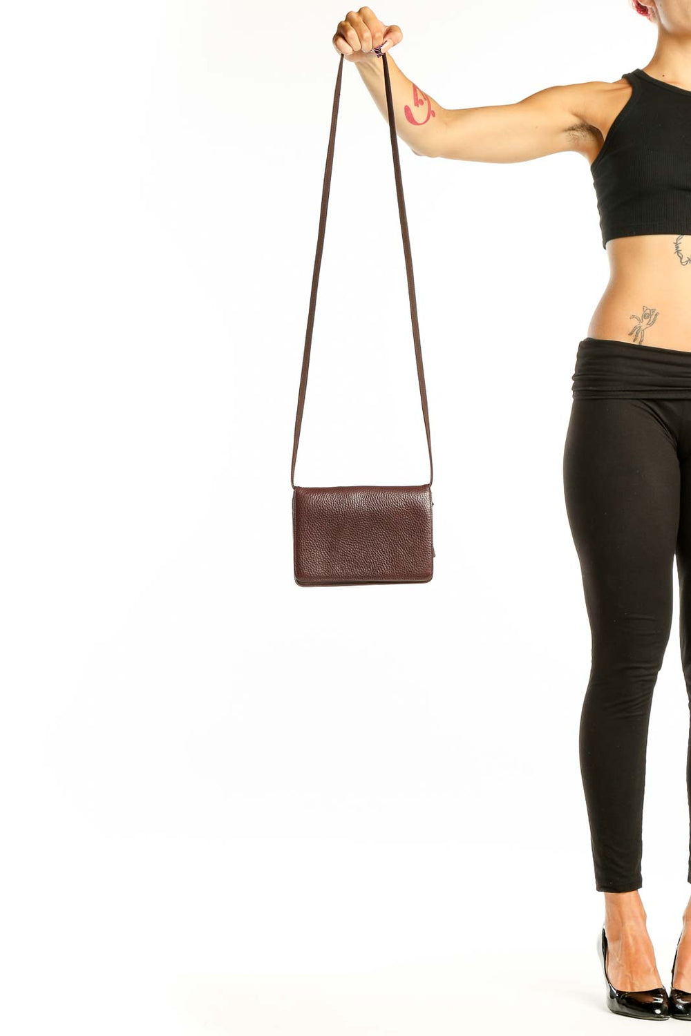 Front view of brown leather Classiques Entier crossbody bag held by model's hand