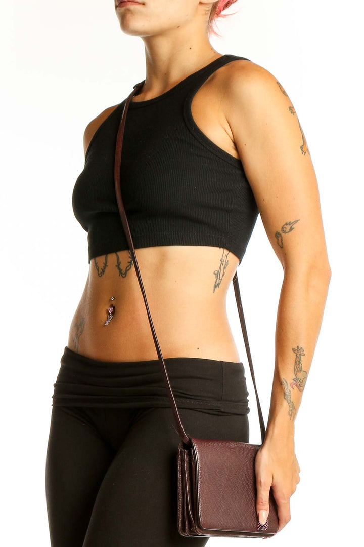 Front view of brown leather Classiques Entier crossbody bag held by model's hand