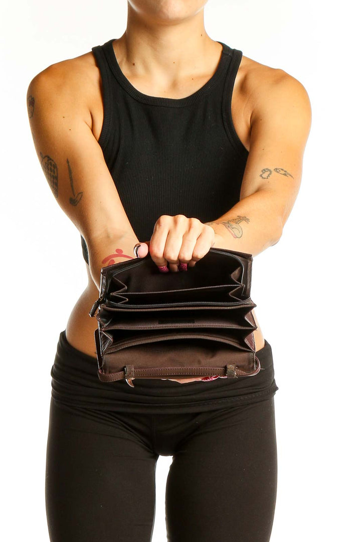 Side view of brown leather Classiques Entier crossbody bag worn by model in black outfit