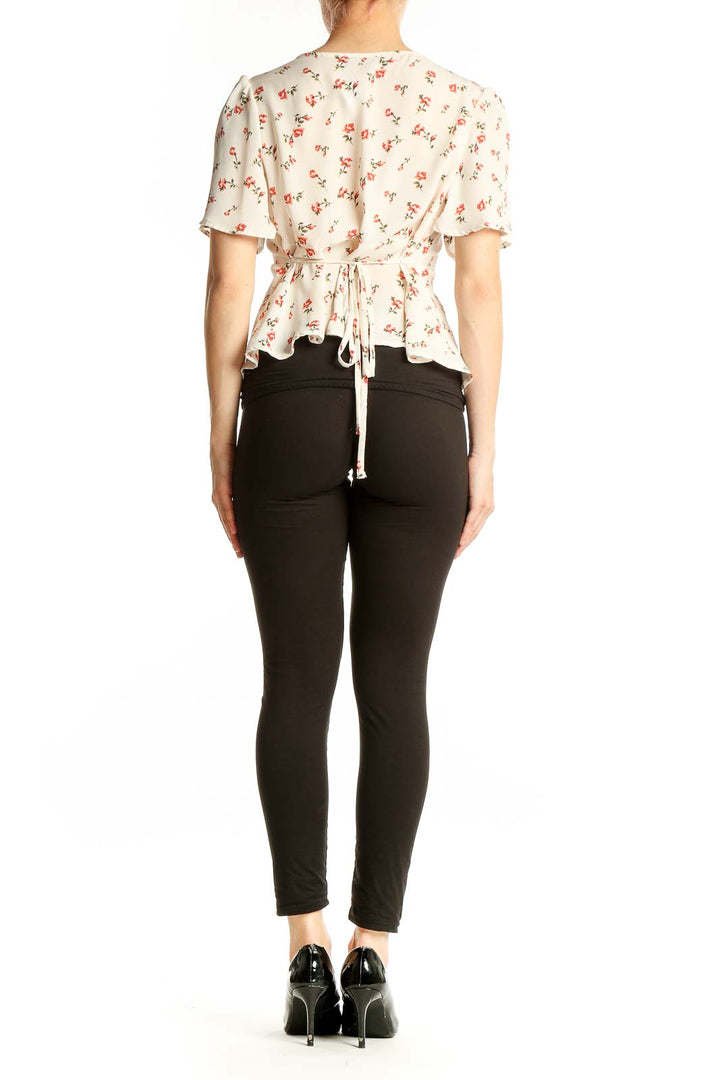 Back view of cream floral Papermoon blouse showing flutter sleeves and fitted waist