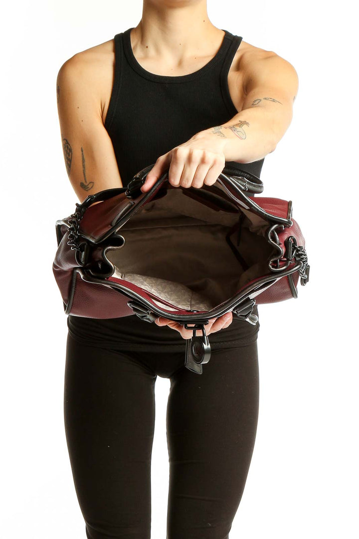 Side view of Michael Kors burgundy leather tote bag worn on shoulder
