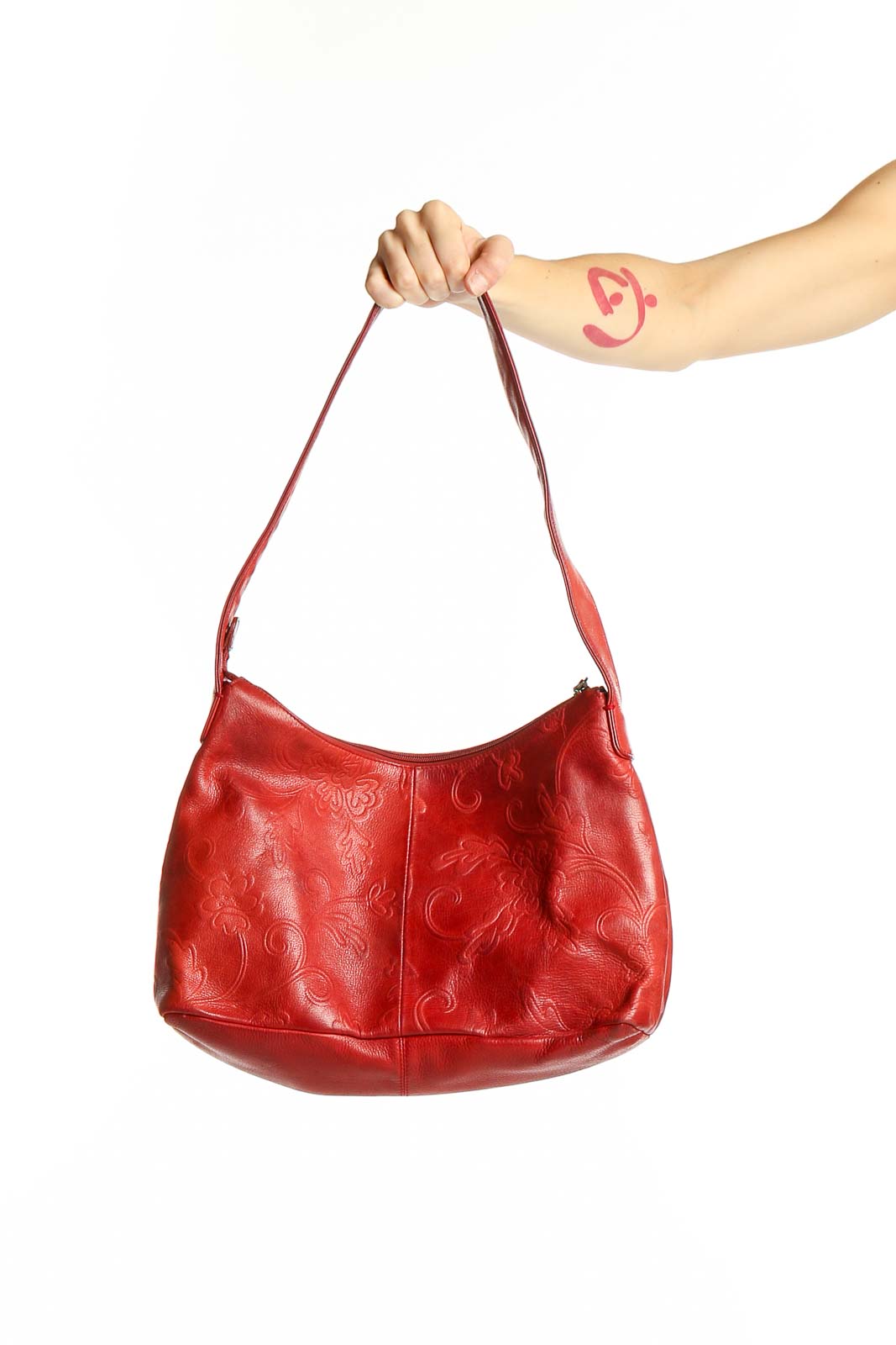Front view of red embossed leather Fossil hobo bag held by hand