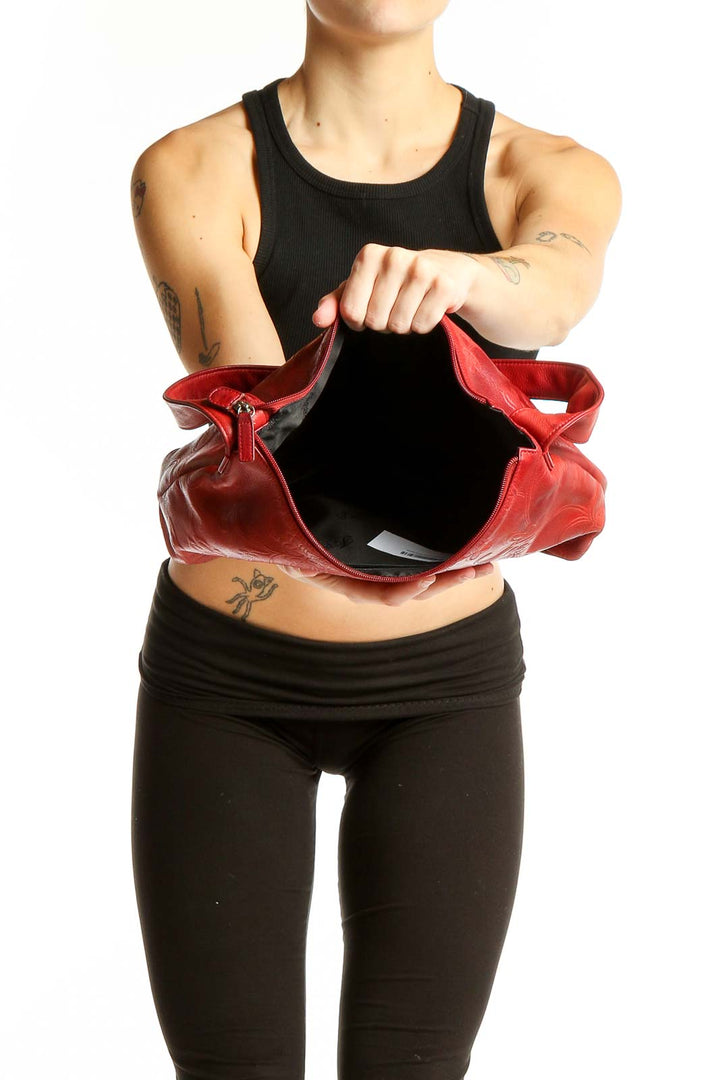 Side view of red embossed leather Fossil hobo bag worn on shoulder