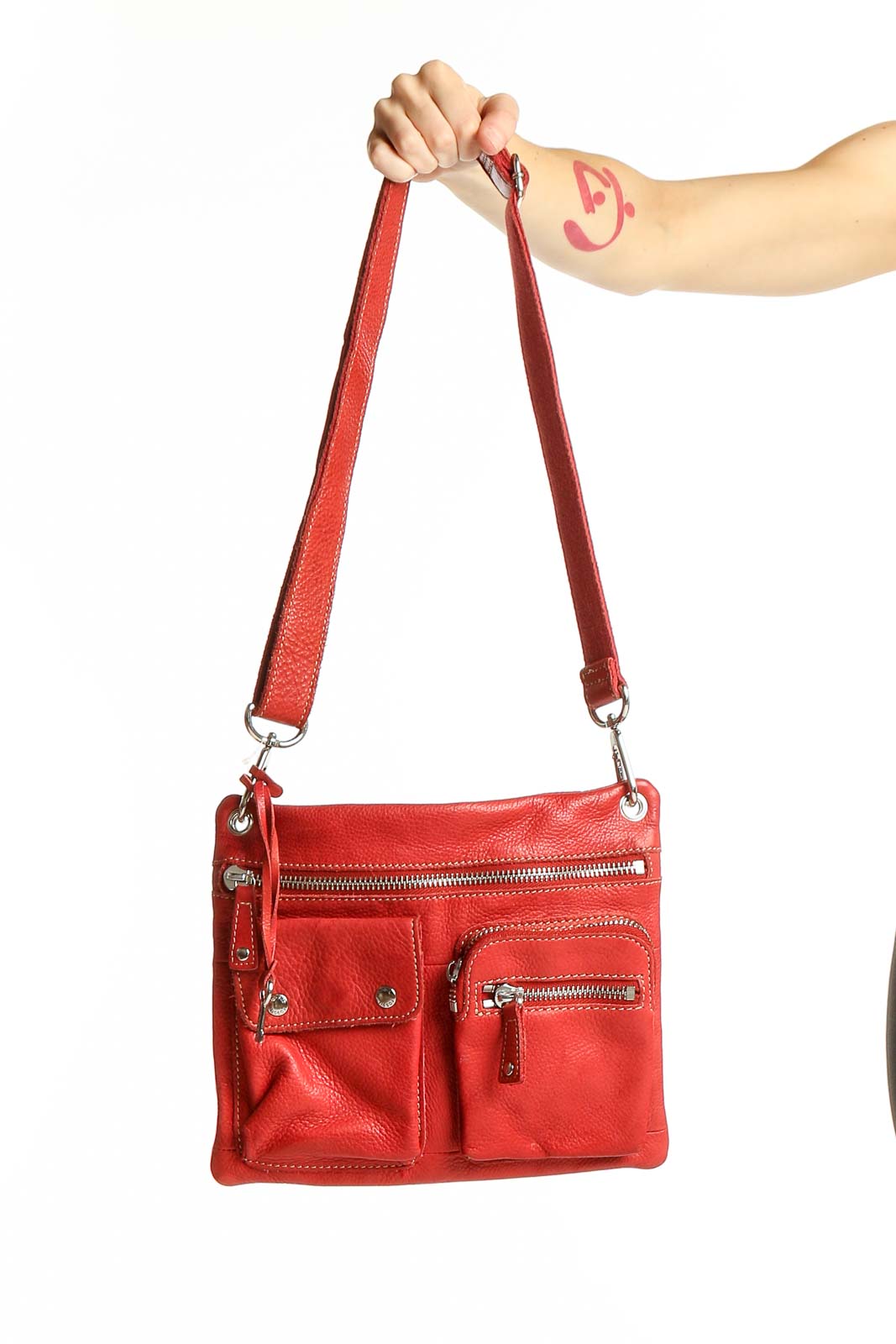 Front view of red leather Fossil crossbody bag with multiple zippered pockets