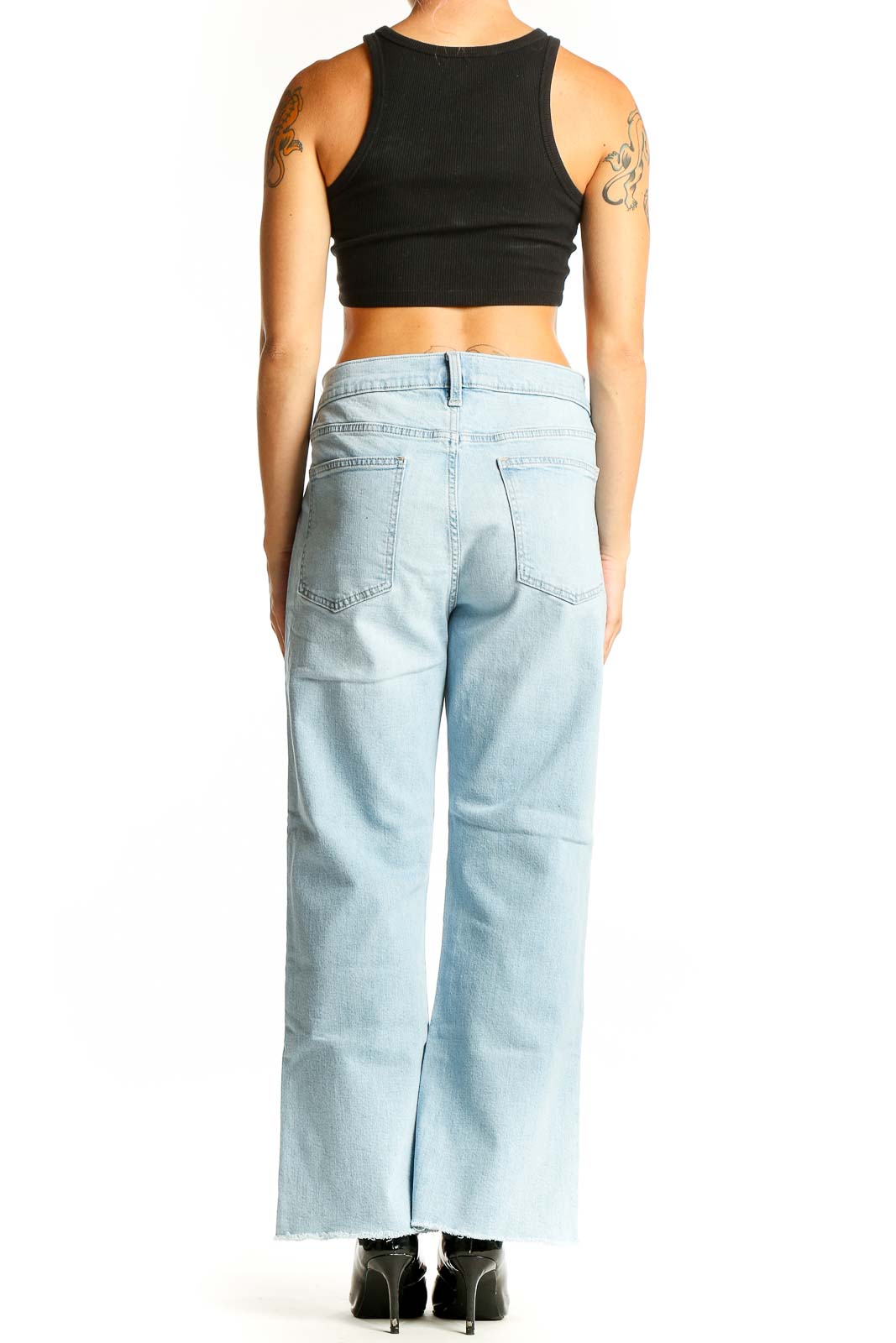 Side view of woman wearing Gap light blue wide-leg jeans with black crop top