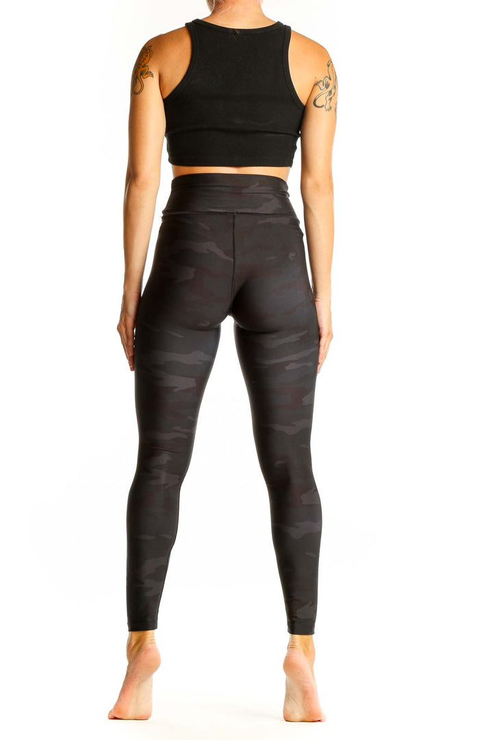 Side view of Barrys black camo high-waisted leggings on model with black crop top