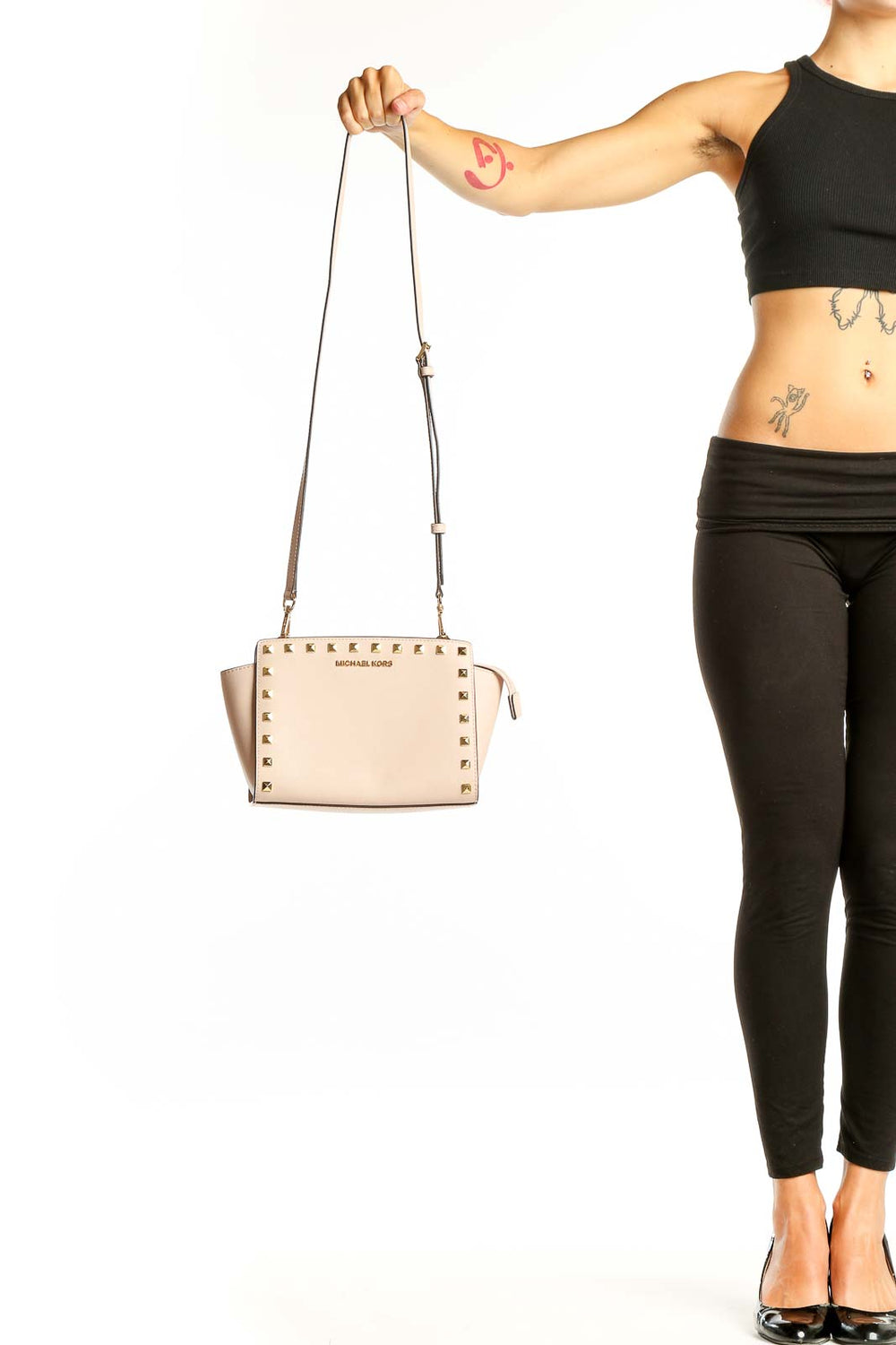 Front view of Michael Kors beige studded leather crossbody bag