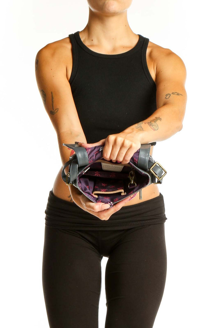Side view of woman wearing Anuschka gray leather crossbody bag with floral and butterfly design