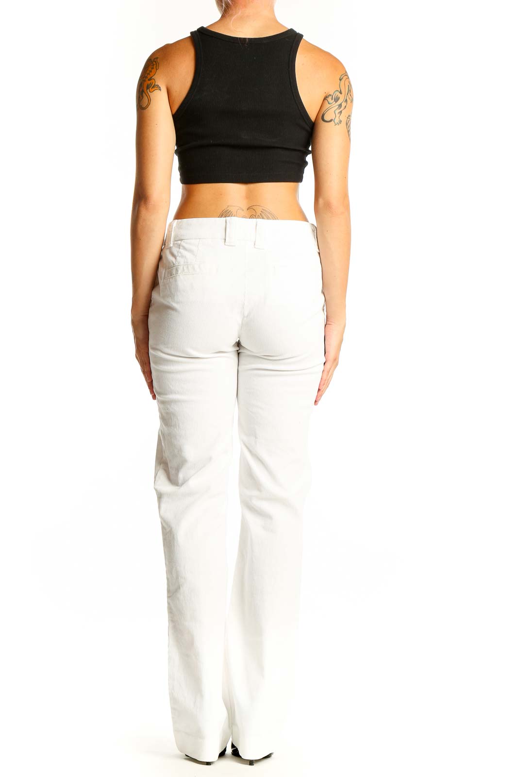Side view of J.Crew white straight leg pants on model with black crop top