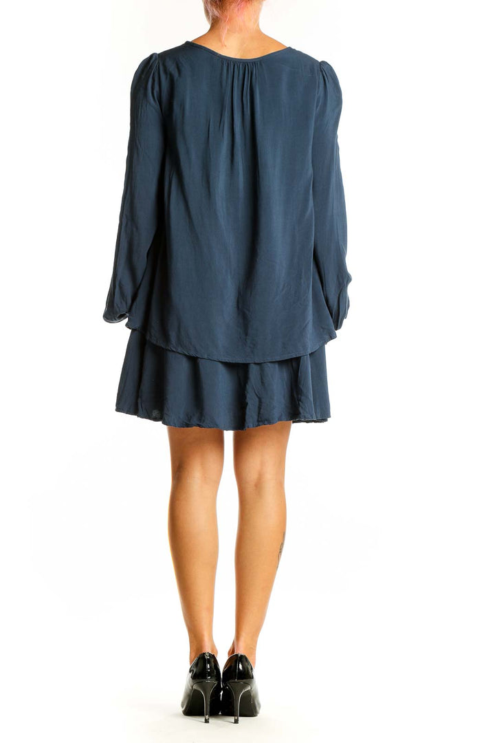 Side view of navy Free People mini dress showing flowy silhouette and bishop sleeves