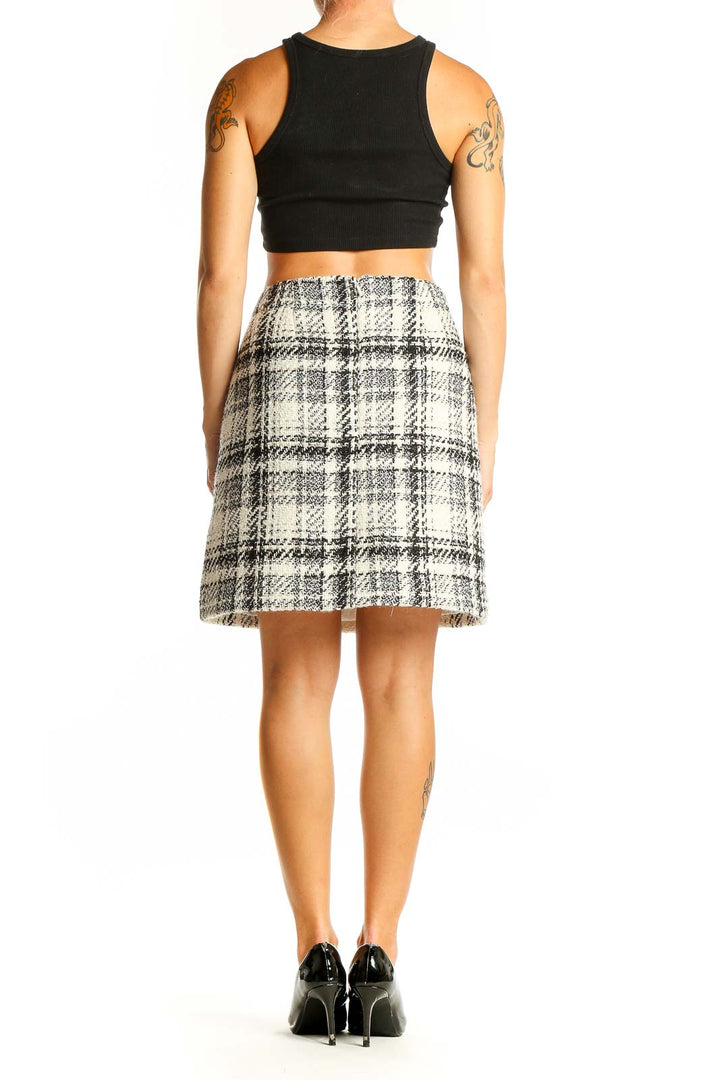 Side view of model wearing LOFT black and white plaid wool-blend mini skirt with black top