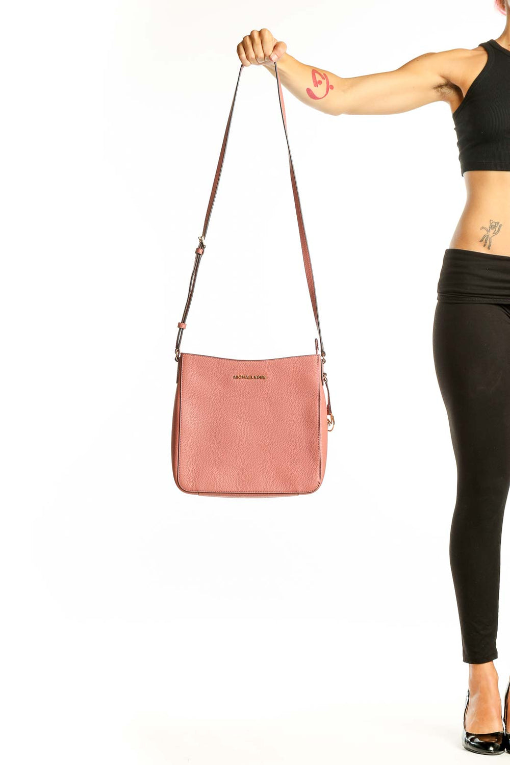 Front view of pink leather Michael Kors crossbody bag