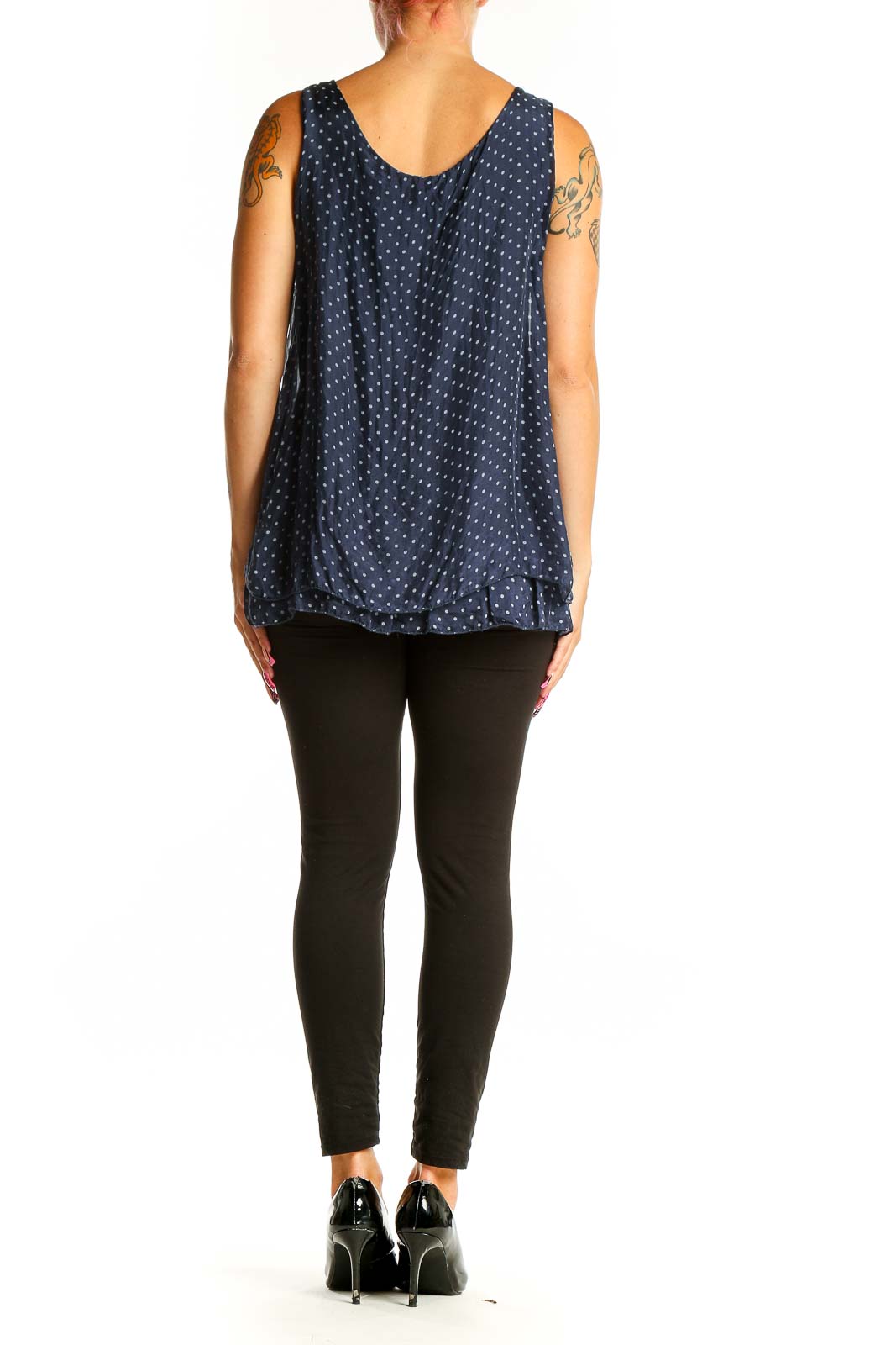 Side view of model wearing GIUSY navy polka dot sleeveless blouse with black pants