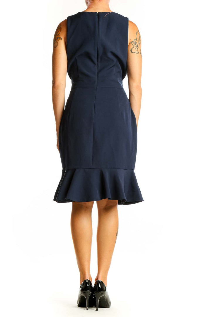 Back view of London Times navy sleeveless dress showing flounce hem detail
