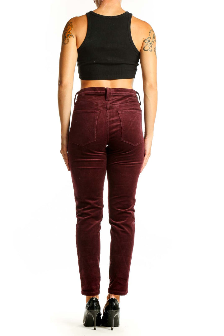 Side view of Banana Republic burgundy velvet slim-fit pants on model with black crop top