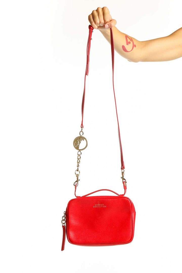 Front view of red Versace leather crossbody bag with gold-tone hardware