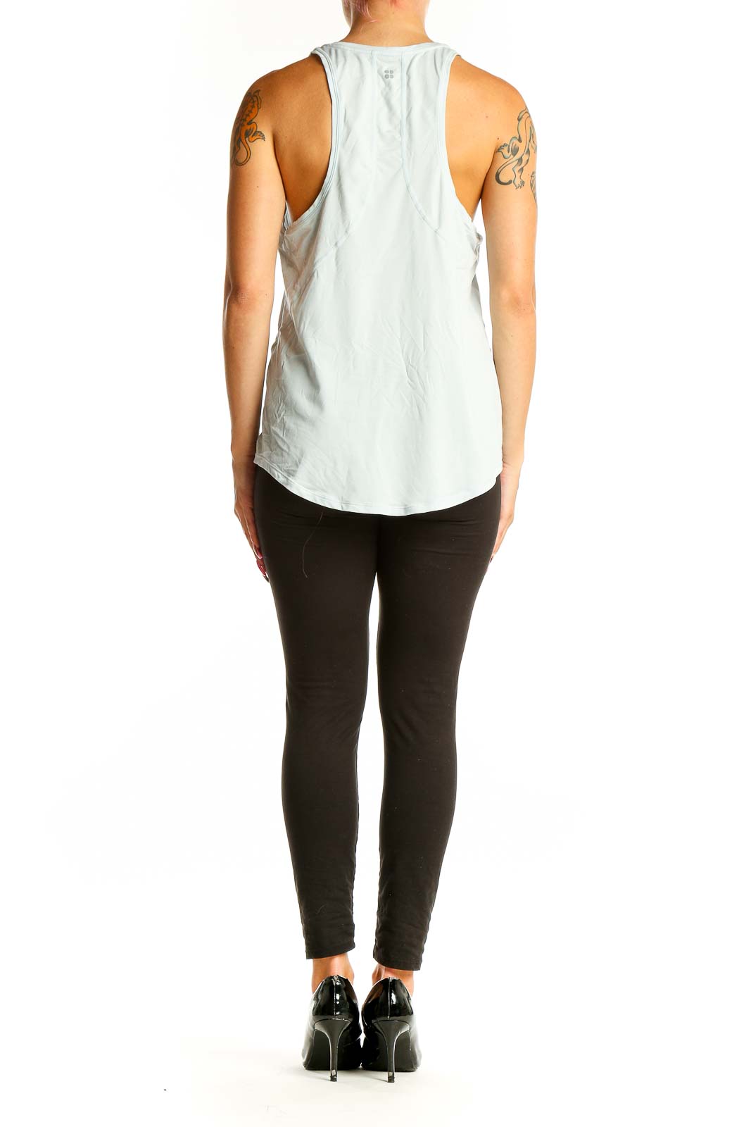 Side view of light blue Sweaty Betty tank top on model with black leggings