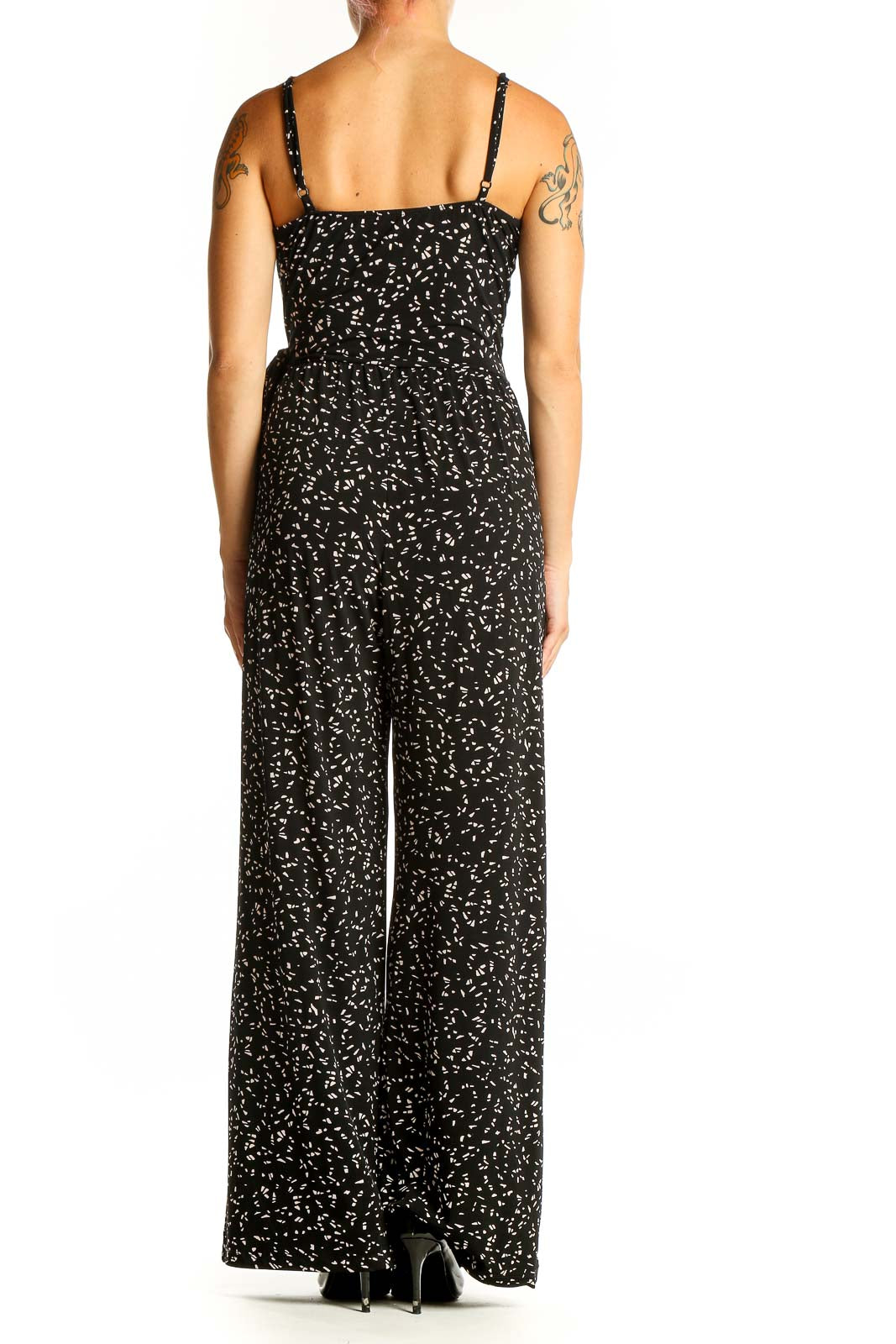 Side view of Kaileigh black floral print jumpsuit showing fitted waist and flowing pants