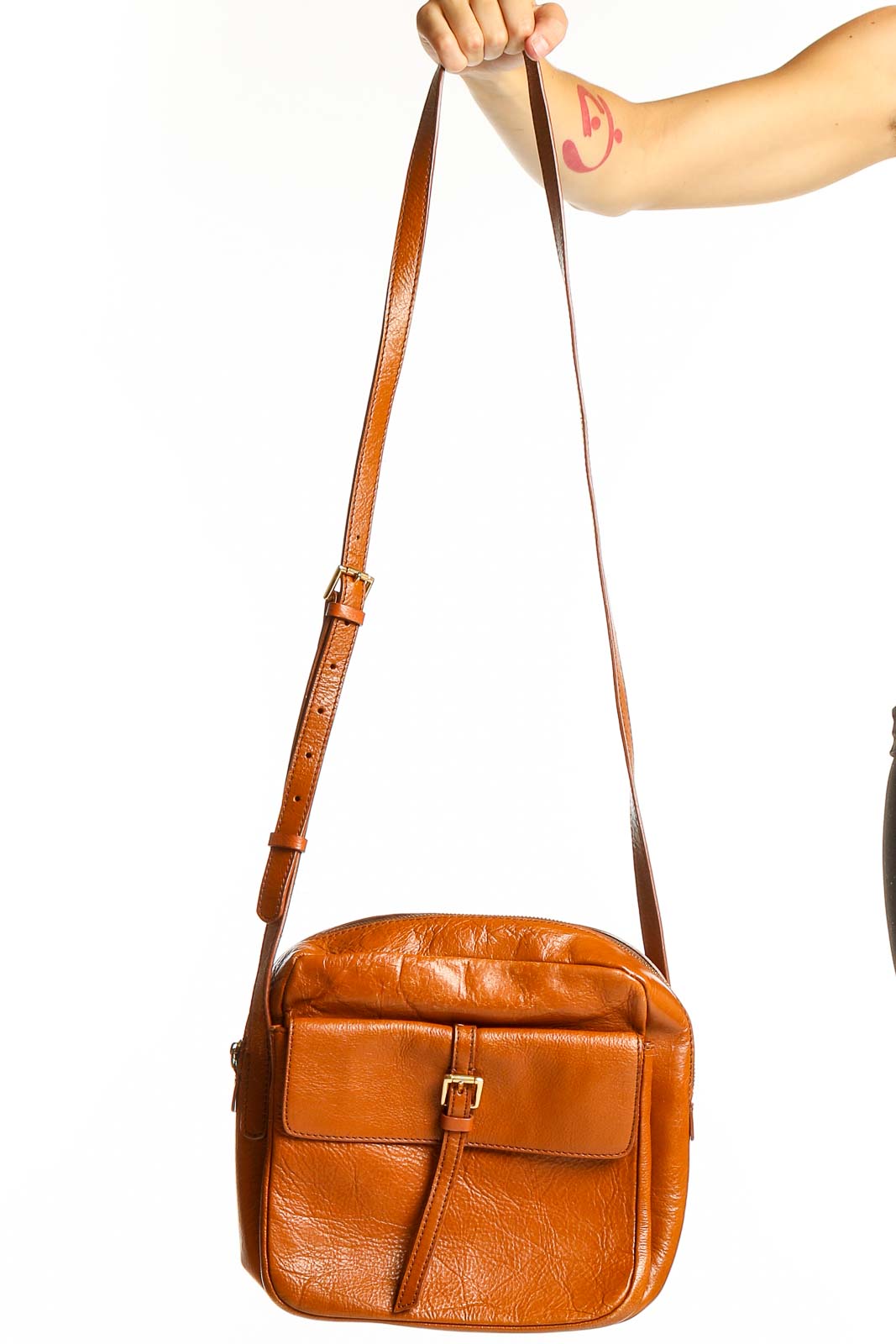 Front view of tan leather SilkRoll crossbody bag with buckle detail
