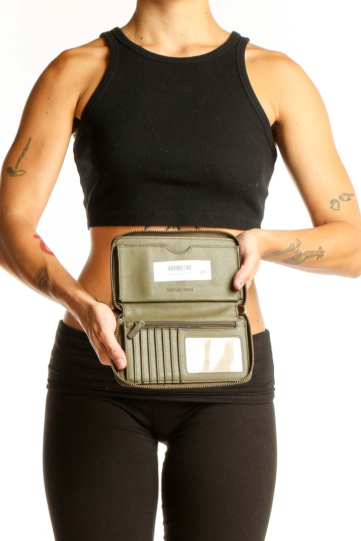 Michael Kors olive leather wallet shown with athletic wear