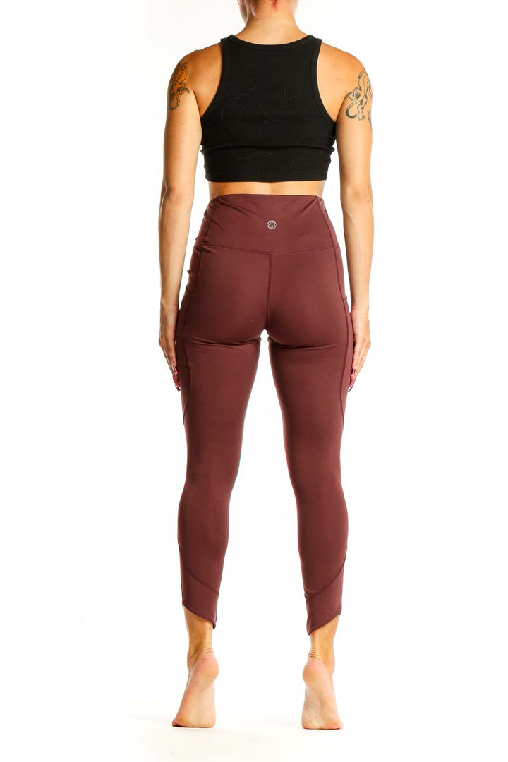 Side view of woman wearing burgundy Aventura high-waisted leggings with black crop top
