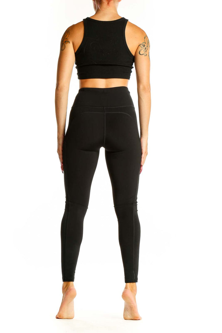 Side view of woman wearing The North Face dark green high-waisted leggings