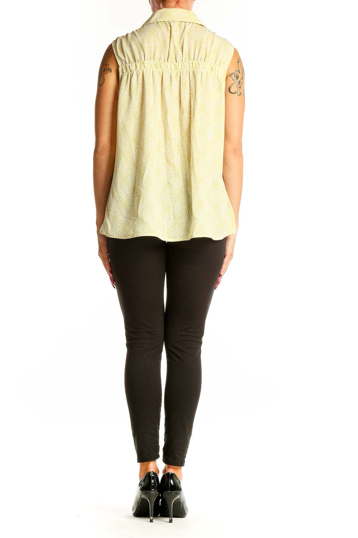 Side view of Pleione yellow sleeveless blouse on model