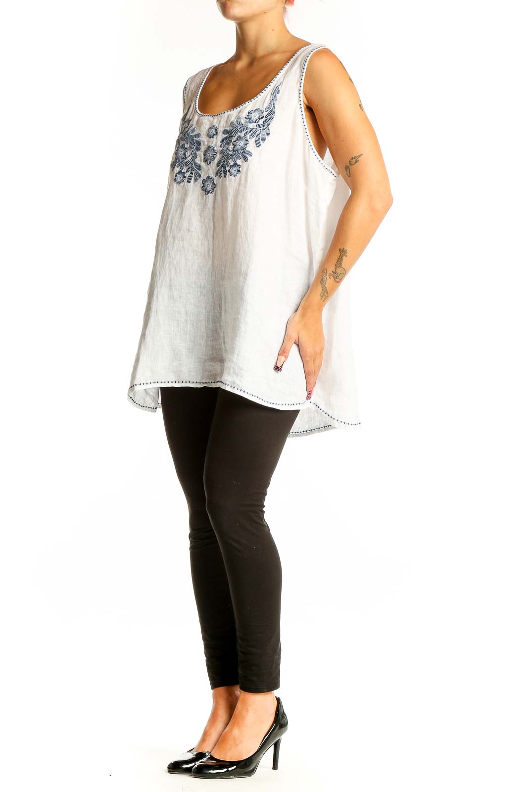 Front view of white linen sleeveless top with blue floral embroidery