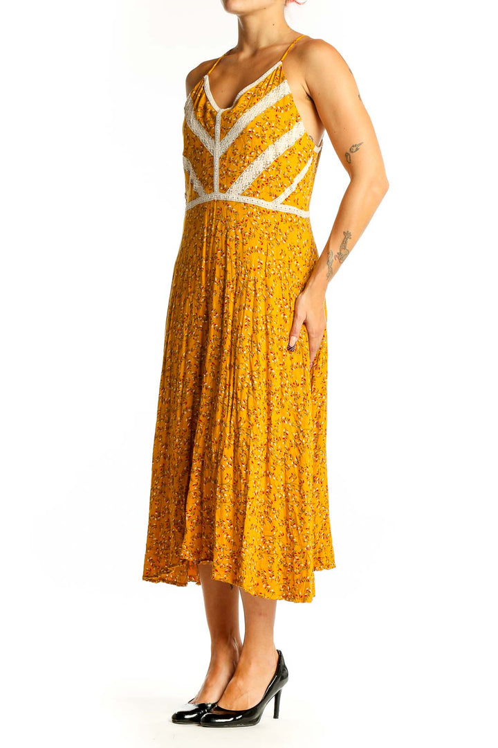 Front view of yellow floral Doe & Rae midi dress with white lace trim