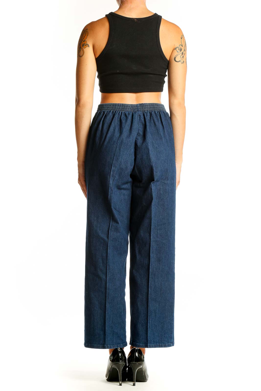Side view of model wearing Alfred Dunner blue wide-leg denim trousers with black top