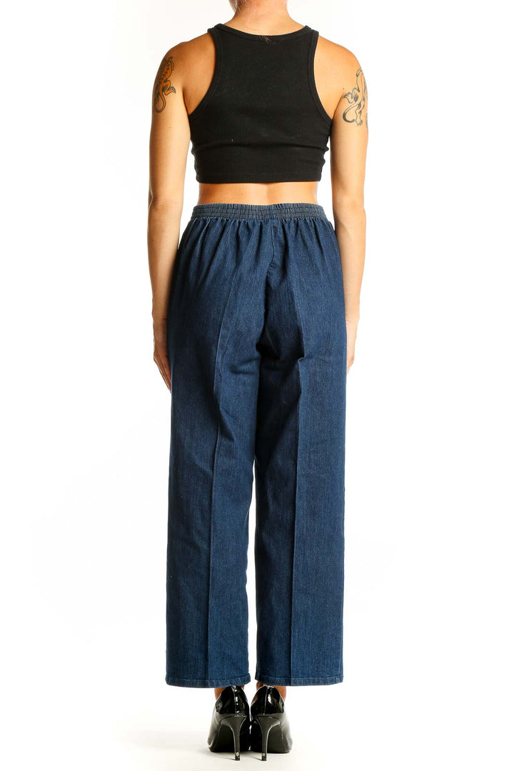 Side view of model wearing Alfred Dunner blue wide-leg denim trousers with black top