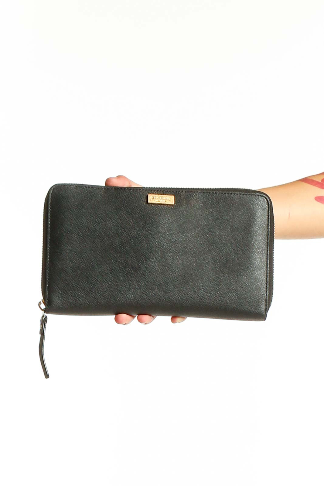 Front view of Kate Spade black leather clutch wallet held in hand