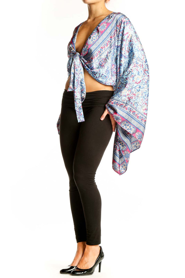 Front view of Galita Blue Floral Paisley Tie-Front Crop Top with long bell sleeves