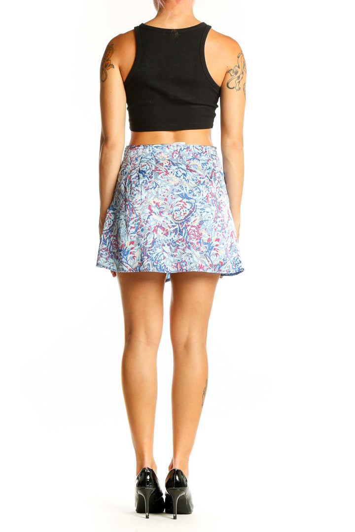 Side view of model wearing Galita blue floral print mini skirt with black top