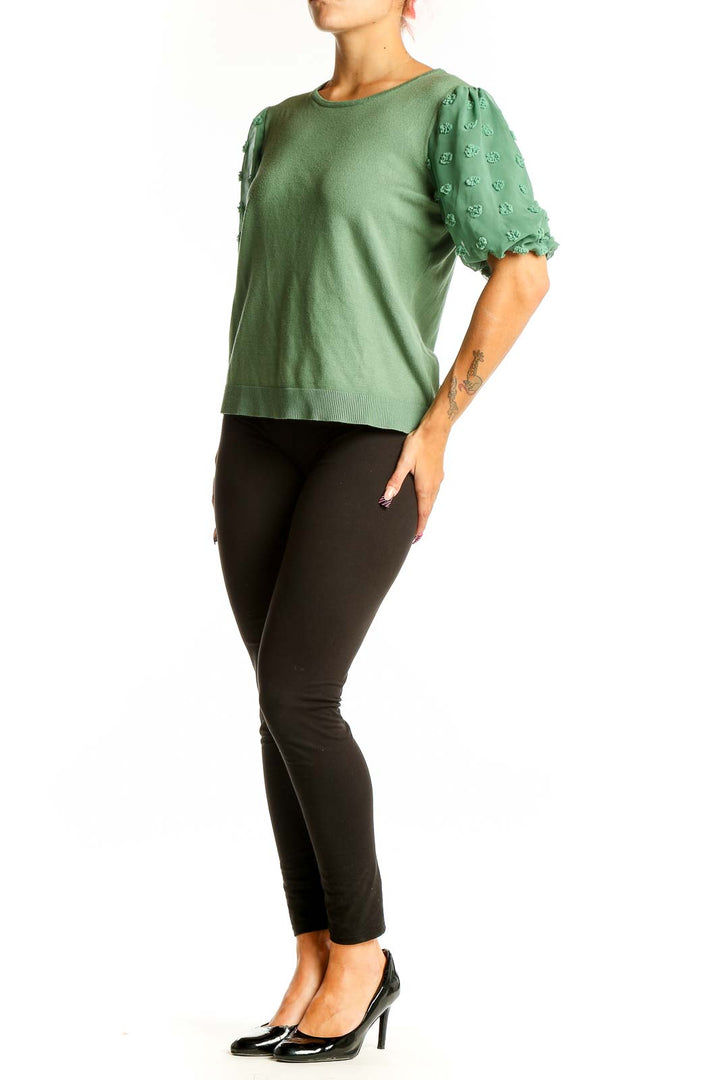 Front view of Adrianna Papell green knit top with floral appliqué puff sleeves