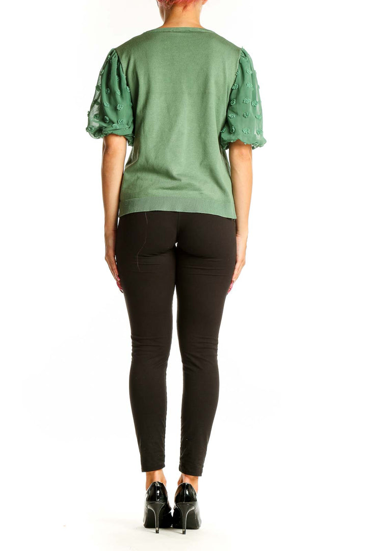 Side view of Adrianna Papell green knit top showing puff sleeve detail