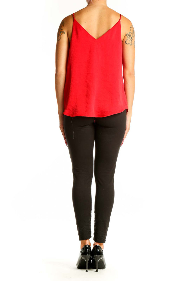 Side view of red V-neck polyester camisole from Express with black pants