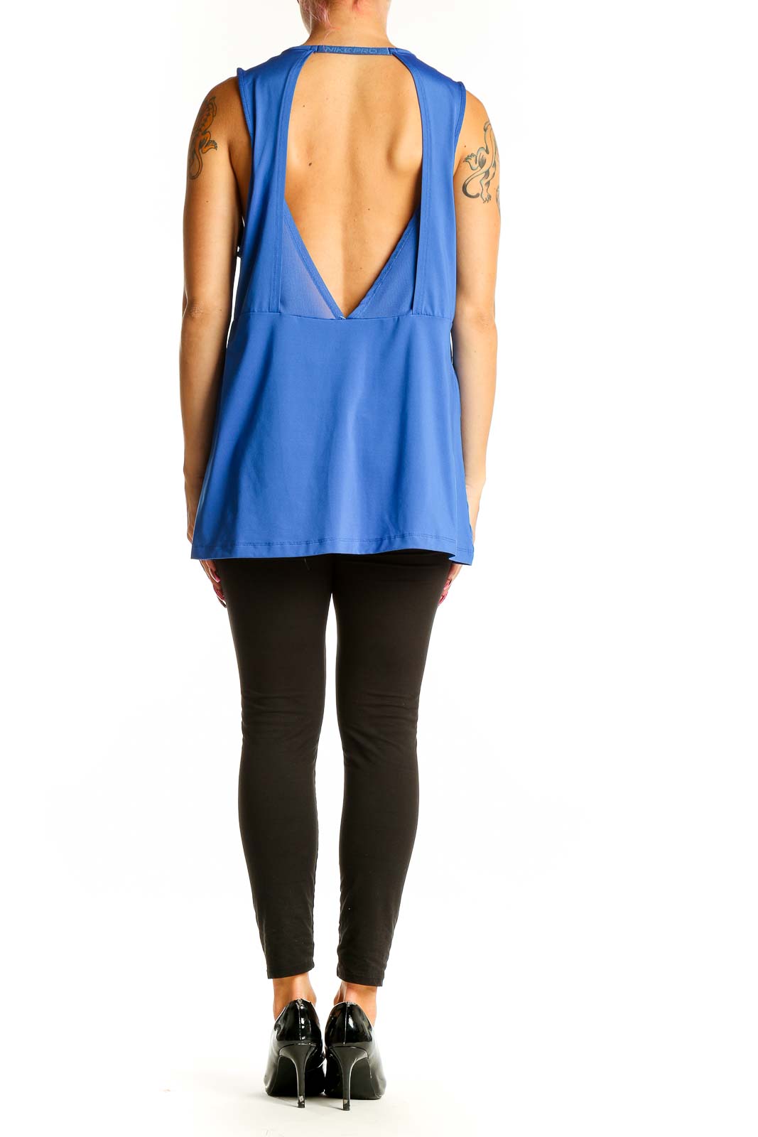Back view of blue Nike performance tank top on model with black leggings